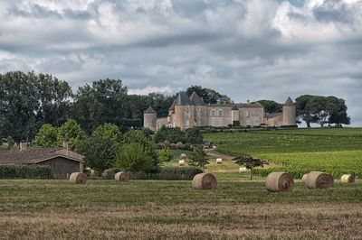 Hay bales on field against sky