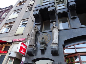 Low angle view of statue against building in city