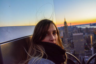 Portrait of young woman against sky during sunset