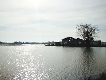 Houses by sea against sky