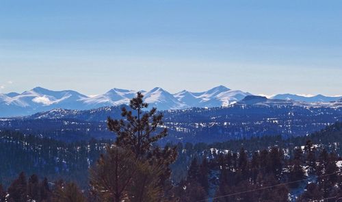 Scenic view of snowcapped mountains against clear blue sky