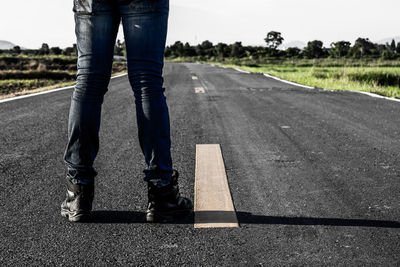 Low section of man standing on road