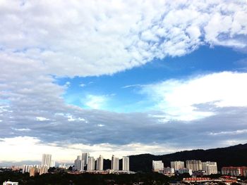 Buildings against cloudy sky