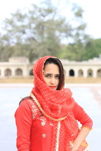 Portrait of young woman standing against red during winter