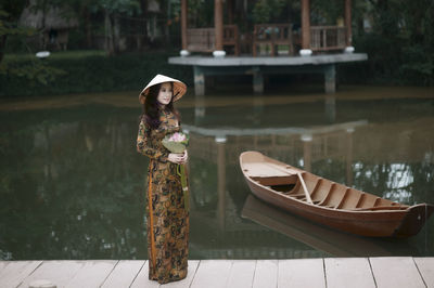 Portrait of woman standing by boat in canal