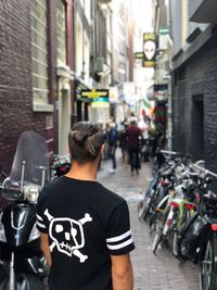 Rear view of man walking on street in city