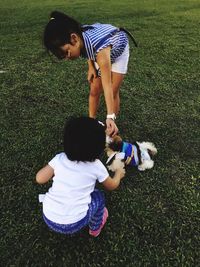 Children playing with puppy on field at park