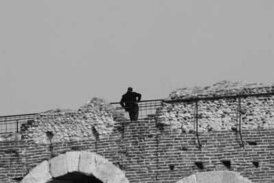 Low angle view of man standing on staircase against sky