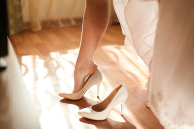 Low section of bride wearing shoes