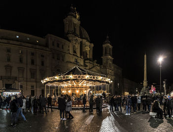 People on illuminated street at night