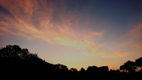 Low angle view of silhouette trees against sky at sunset