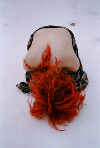 High angle view of topless woman bending on snowfield