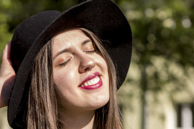 Close-up of smiling young woman wearing hat