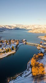 Scenic view of river by snowcapped mountains against sky