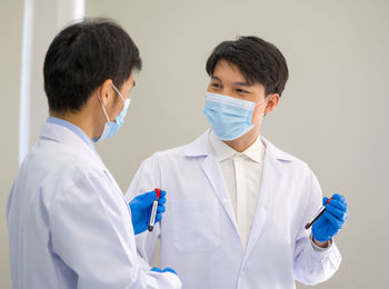 Scientists wearing mask standing in laboratory