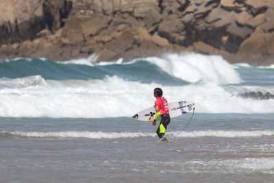 Full length of man surfing in sea against sky