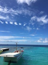 Boats in sea against cloudy sky