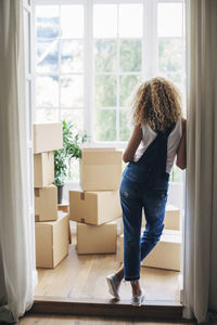 Rear view of woman standing at doorway in new house