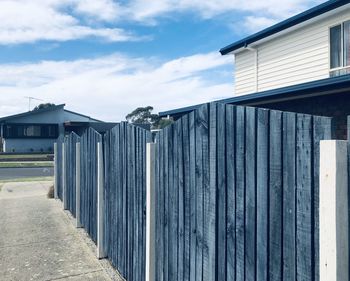 Row of houses by building against sky