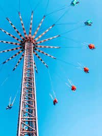 Low angle view of ferris wheel against clear blue sky