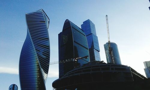 Low angle view of modern buildings against blue sky