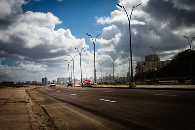 Cars on street in city against sky