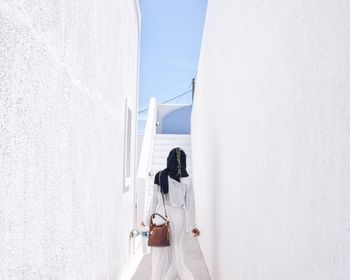 Rear view of woman walking on alley