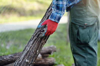 Midsection of man standing on tree trunk