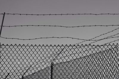 Low angle view of chainlink fence against clear sky