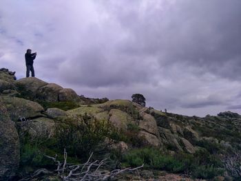 People standing on rock against sky