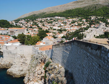 Aerial view of townscape by mountain against sky