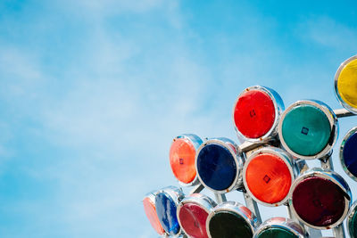 Low angle view of colorful lighting equipment against sky