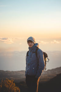 Adventurer standing on edge of a rock on highest mountain pico ruivo on island of madeira, portugal