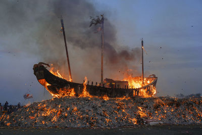 Fire on water against sky at dusk