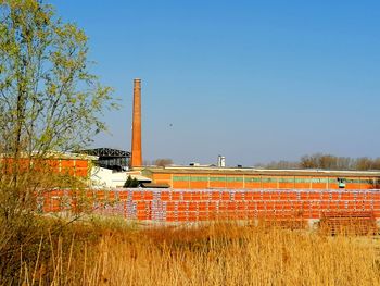 Built structure on field against clear blue sky