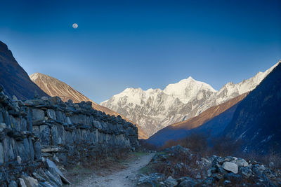 Scenic view of snowcapped mountains against blue sky