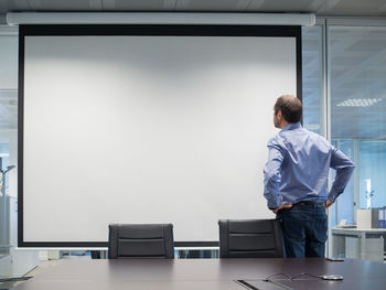 Businessman looking at projection screen in office