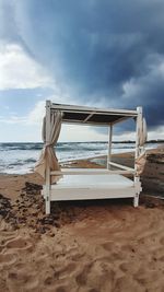 Lifeguard hut on beach against sky