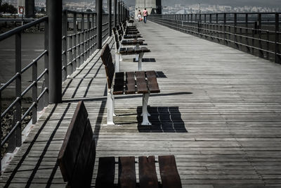 Empty benches on wooden bridge over river