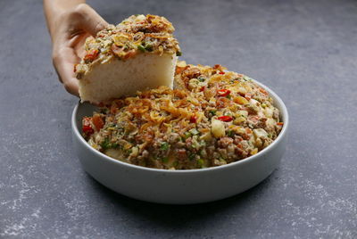 Close-up of hand holding food in bowl