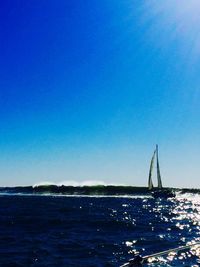 Boat sailing in sea against clear sky