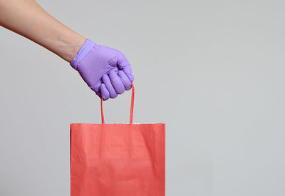 Midsection of woman holding umbrella against white background