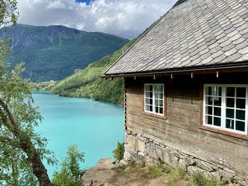 House amidst buildings and mountains against sky