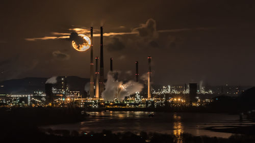 Smoke emitting from factory against sky at night