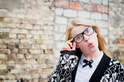 Portrait of young woman against wall