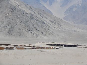 Scenic view of beach and buildings against mountains