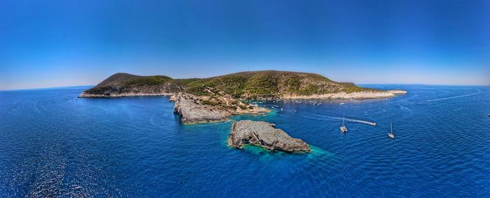 Scenic view of rocks on sea shore against sky
