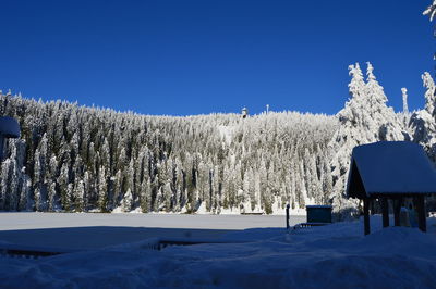 Scenic view of snow covered land against clear blue sky