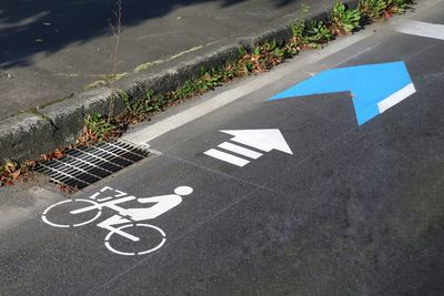 High angle view of arrow symbol on road. bike lane sign.