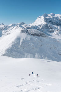 People on snowcapped mountain against sky